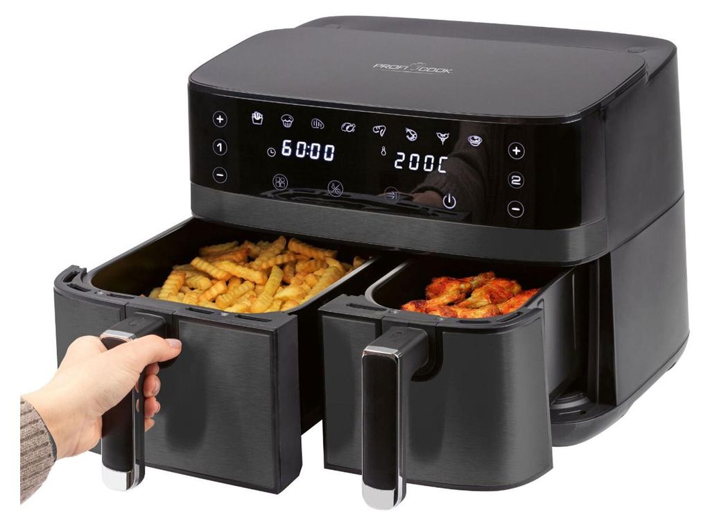 A dual-chamber air fryer with one drawer being pulled out by a hand.