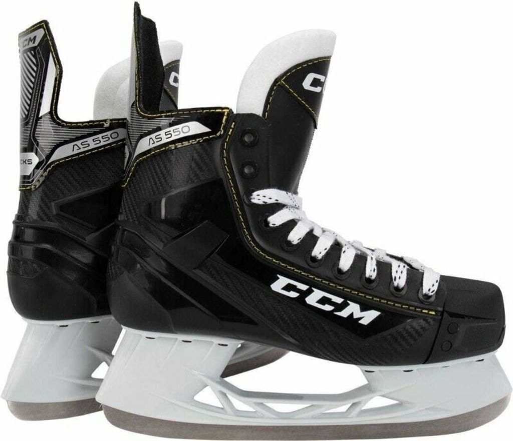 A pair of black CCM Tacks AS 550 hockey skates are shown from a side-angle against a white background.