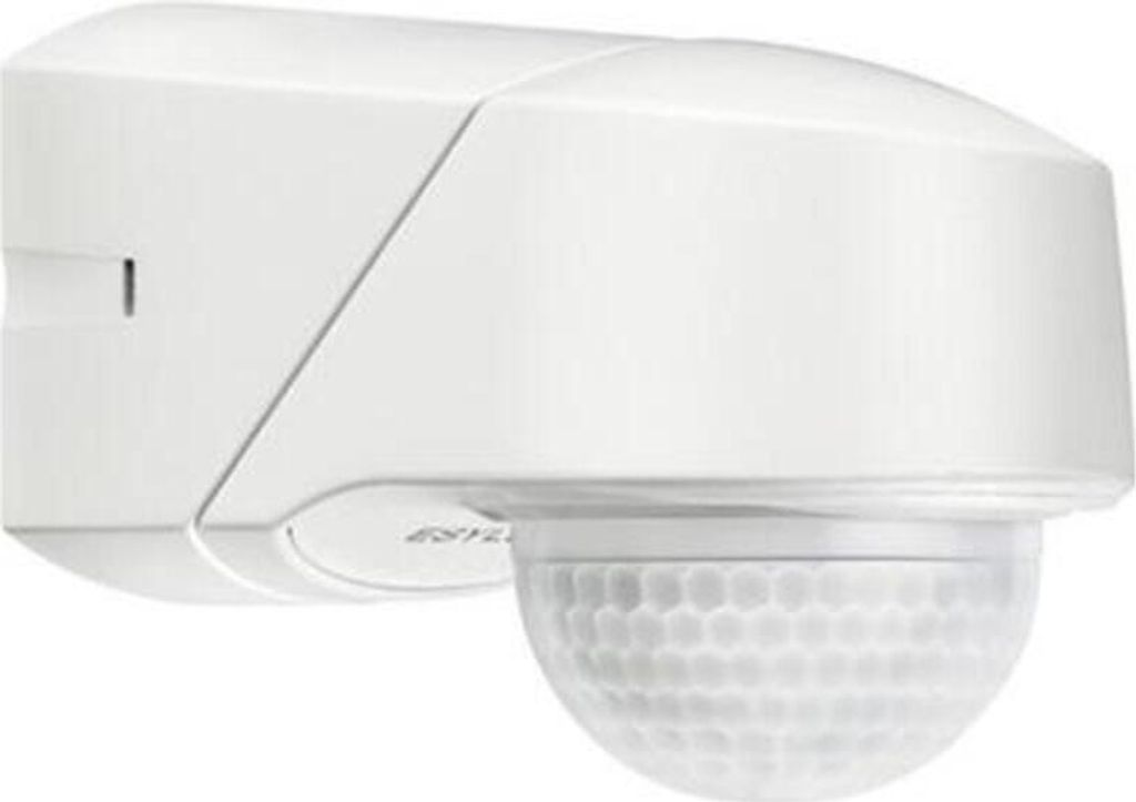 A white motion detector mounted on a wall.