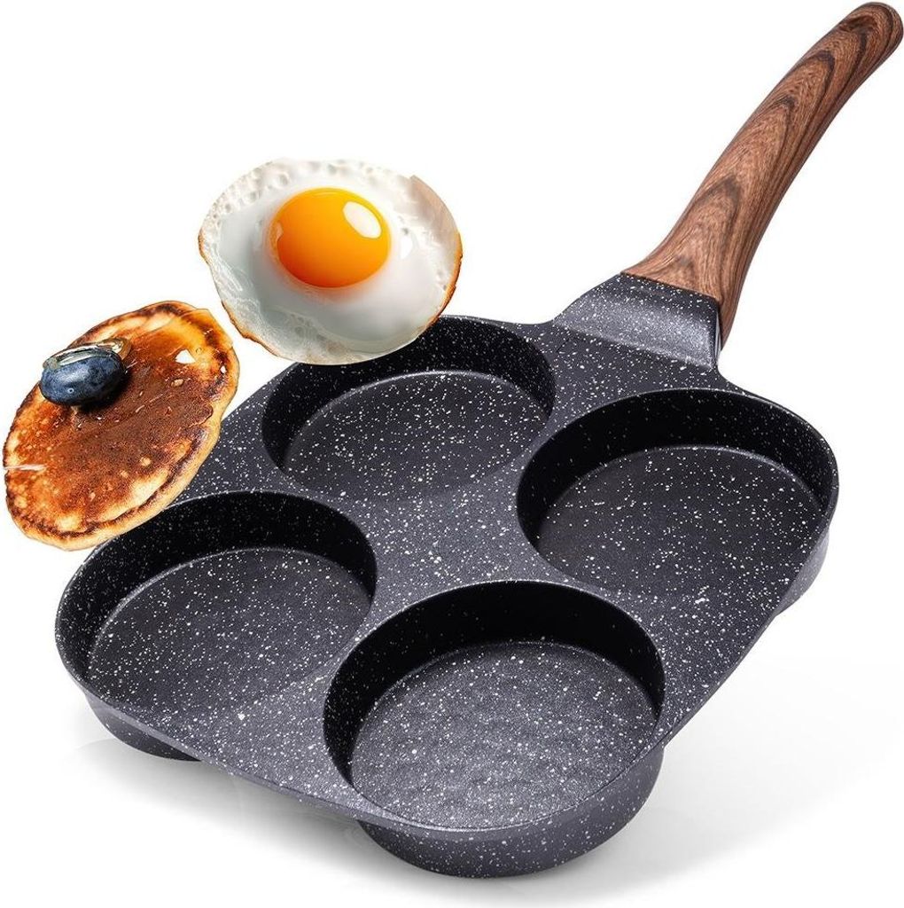 A frying pan with multiple circular molds, designed for cooking eggs or pancakes, is shown with a fried egg and a pancake placed next to it.