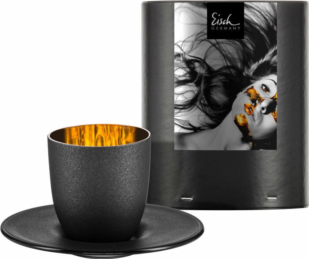 A black espresso cup and saucer are shown next to a cylindrical black packaging with a striking image of a woman's face.