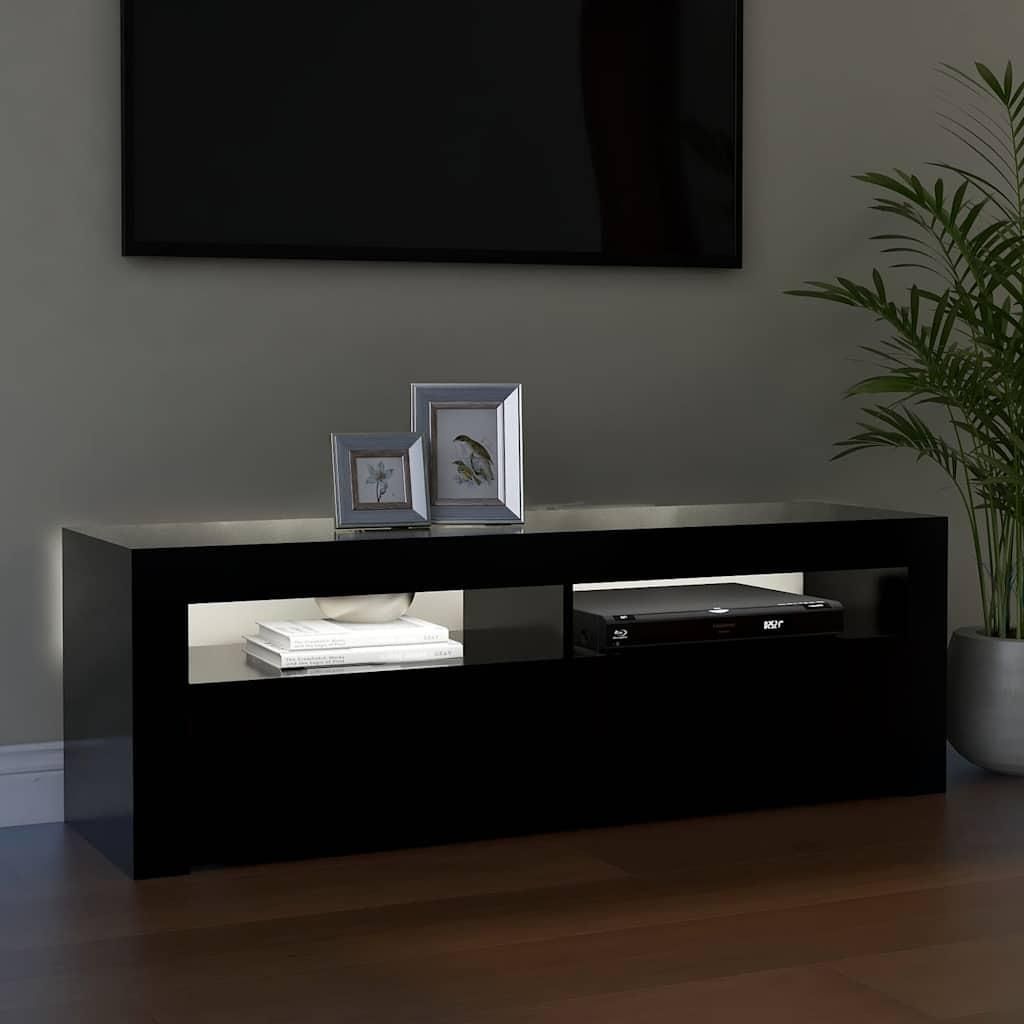 A black TV stand with a DVD player and books on it, in front of a wall with a TV and a plant.