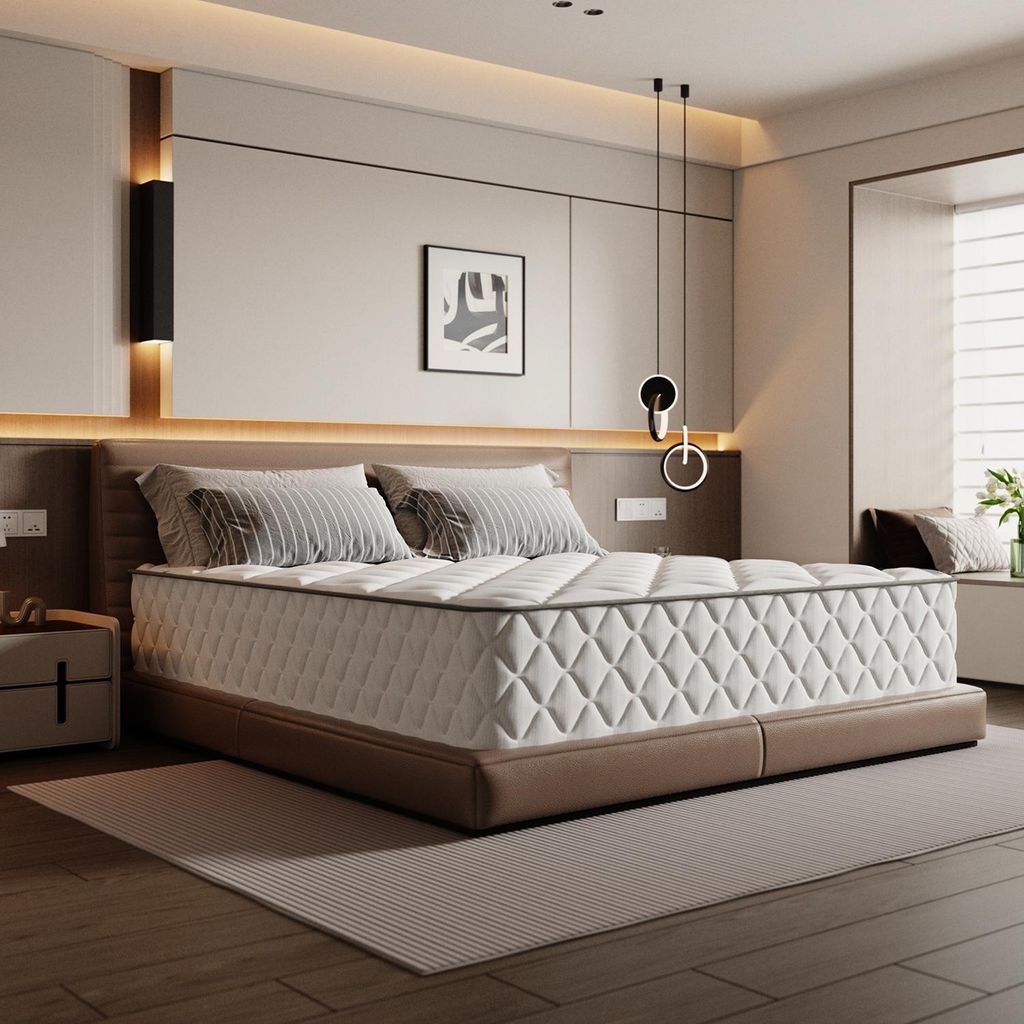 A bedroom scene with a mattress on a bed frame, bedside table, and artwork on the wall.