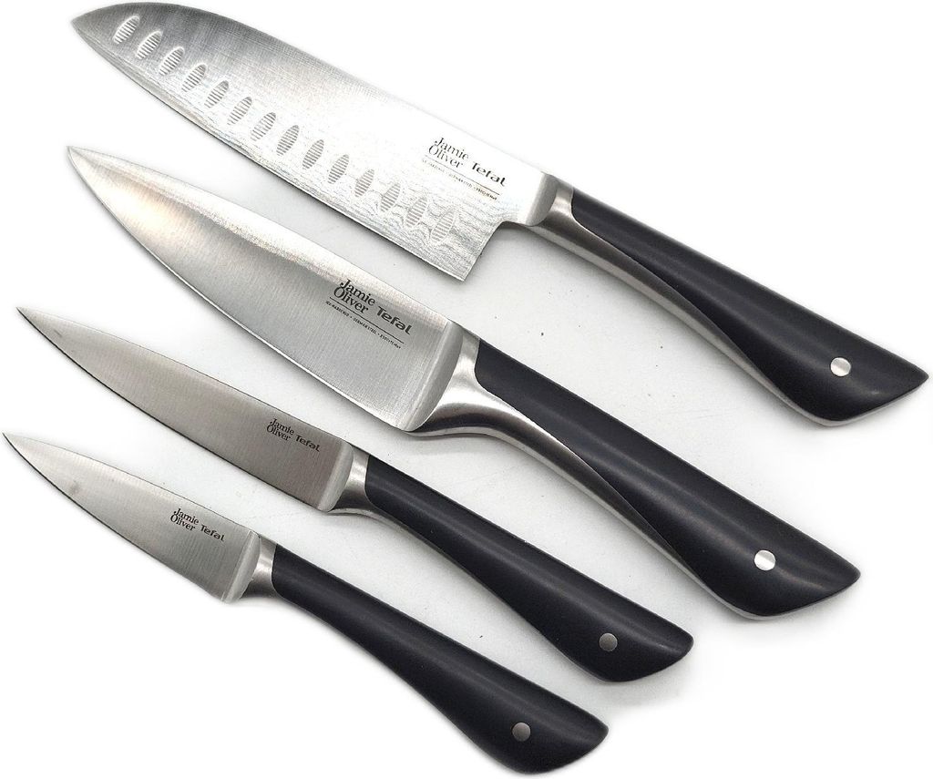 A set of four kitchen knives with black handles, arranged diagonally on a white background.