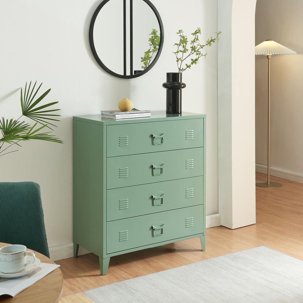 A green metal dresser with four drawers is shown in a room with a mirror, plant, and lamp.