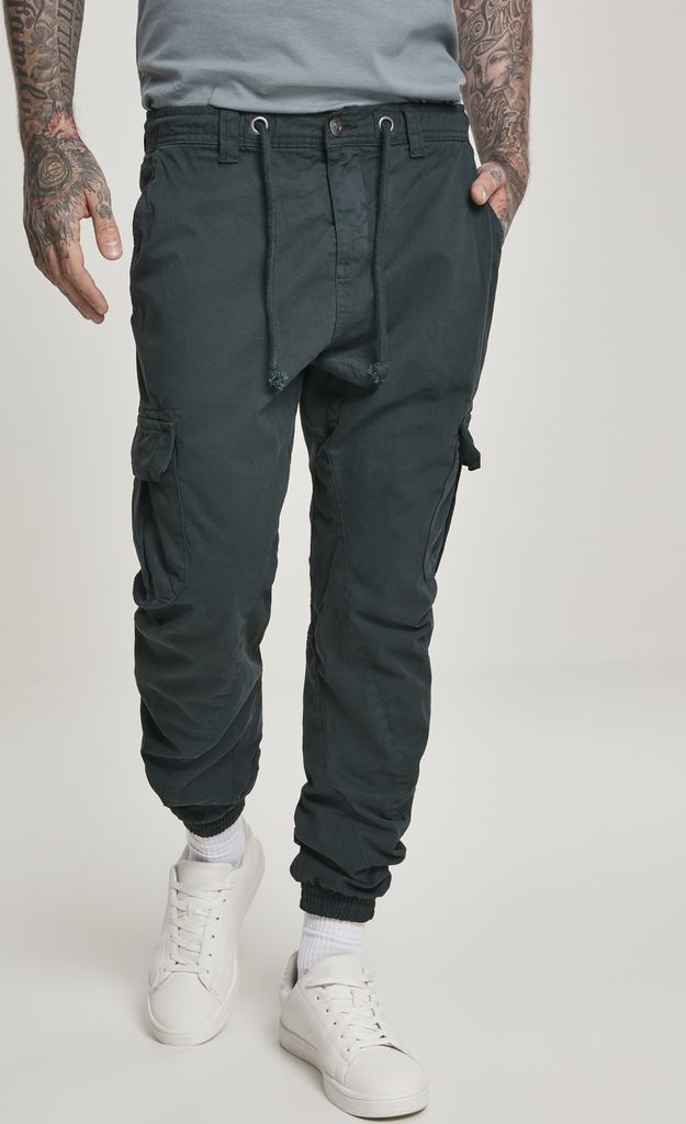 A person wearing black cargo jogging pants and white sneakers, standing against a white background.