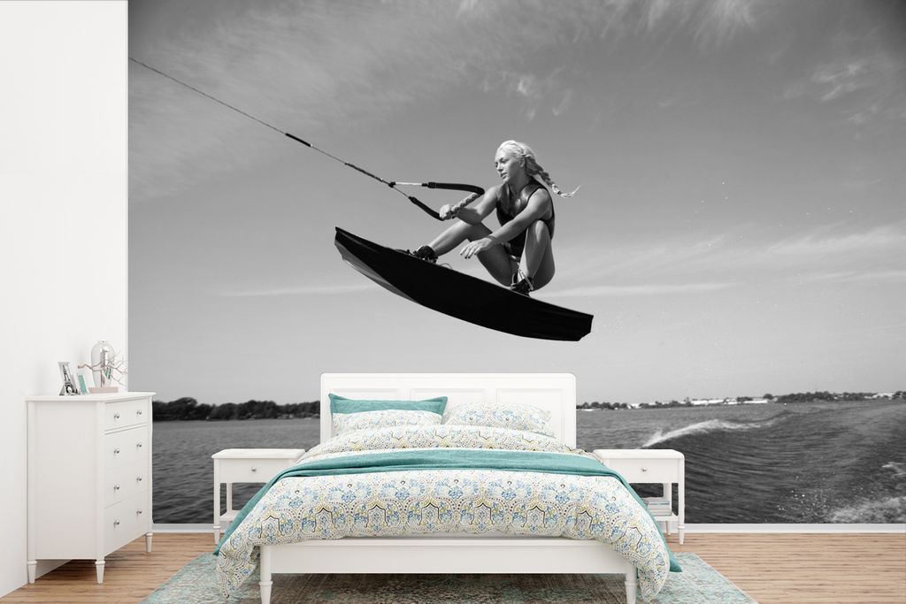 MuchoWow Fototapete für Wohnzimmer oder Schlafzimmer Wandtapete Vinyl Motivtapete Eine sportliche Frau geht auf einem Wakeboard in die Knie - sc...