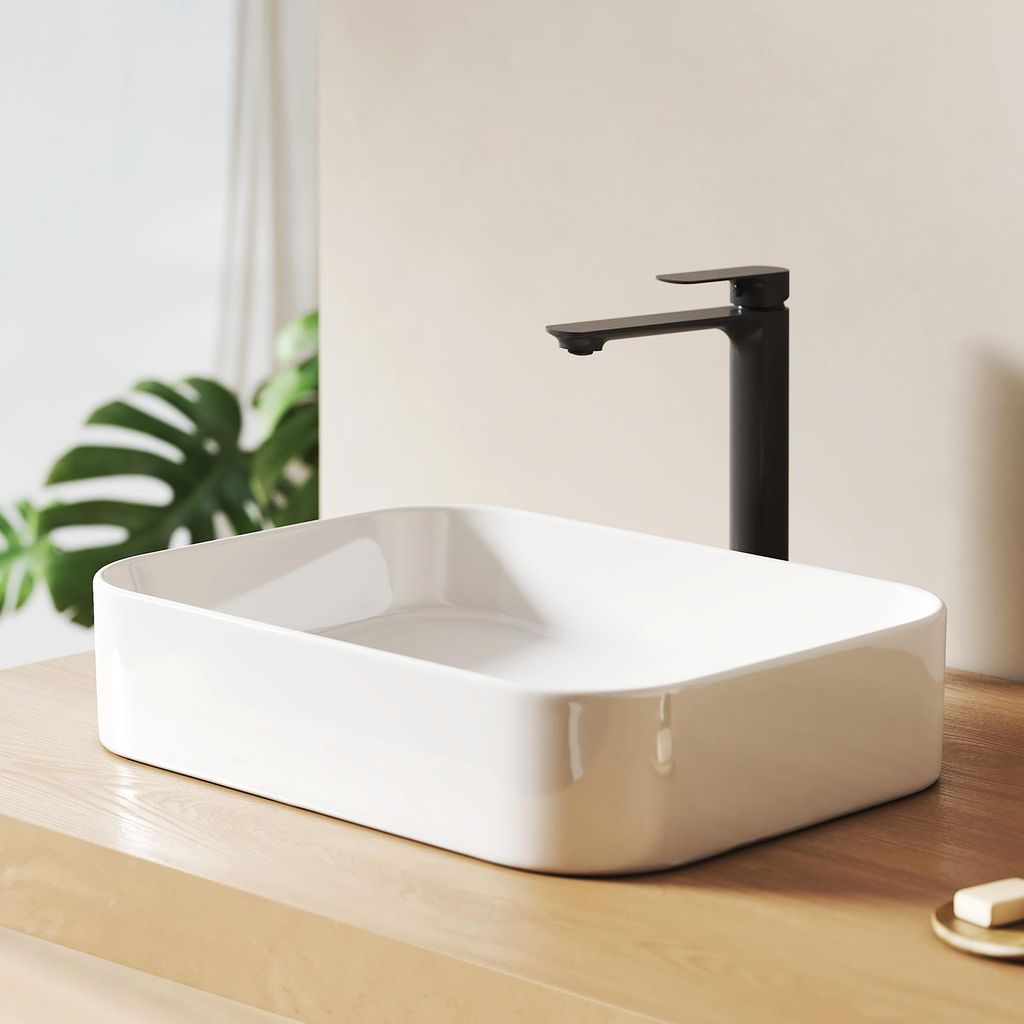 A modern bathroom sink with a black faucet on a wooden countertop.