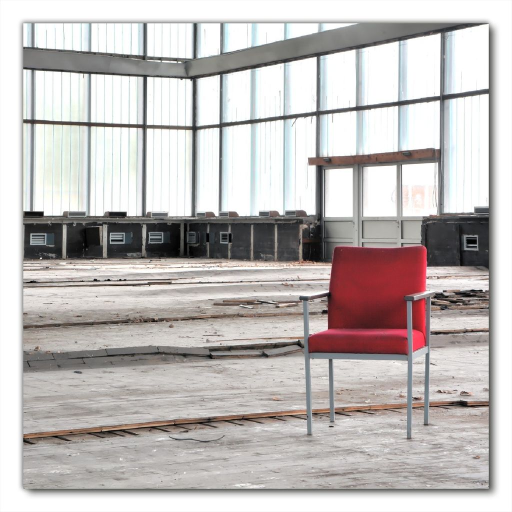 Wallario selbstklebende Möbelfolie/ Tischdecke für Innen und Außen, Größe: 70 x 70 cm - Stille und Leere - ein einsamer roter Stuhl in einer a...