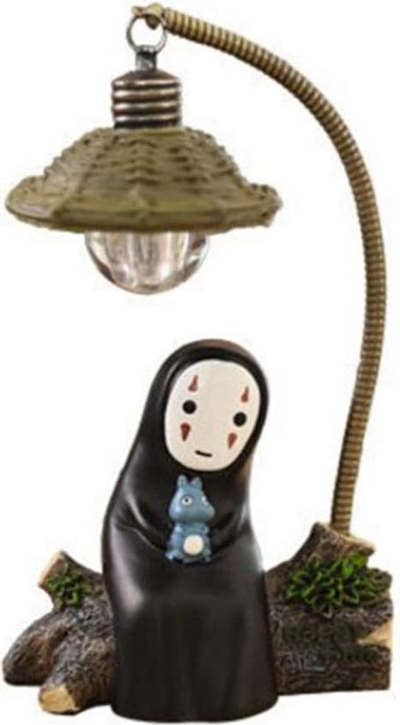 A decorative lamp featuring a character from Japanese animation, with a rustic base.