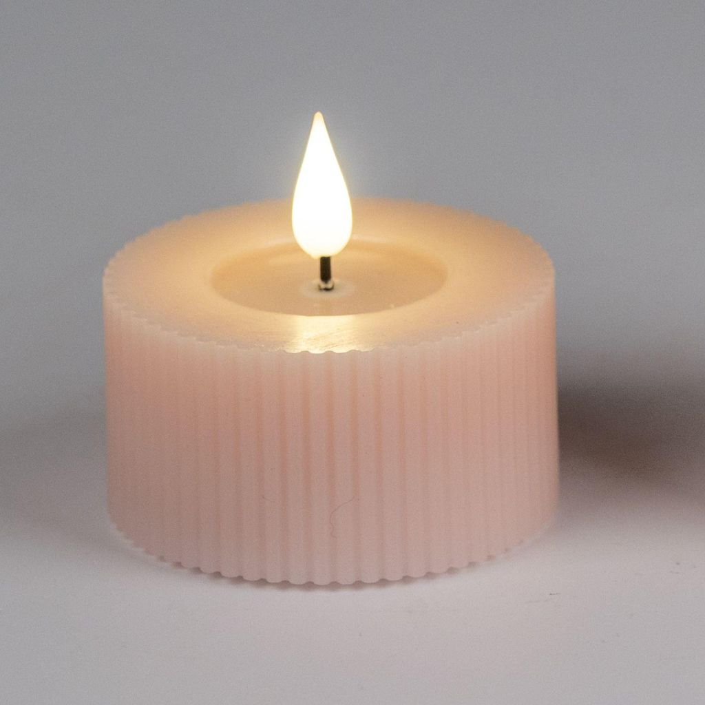A close-up studio shot of a pink LED candle with a lit flame.