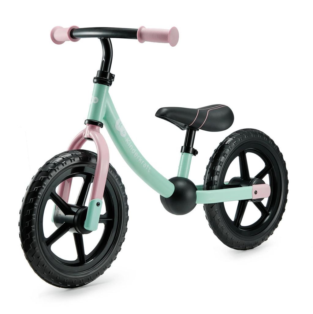 A mint green and pink balance bike with black wheels, shown from a three-quarter front angle against a white background.