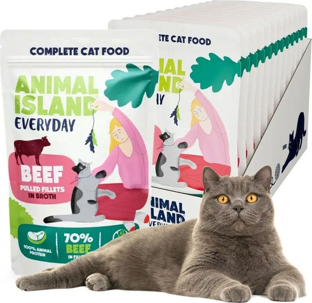 A British Shorthair cat is lying in front of a display of cat food pouches.
