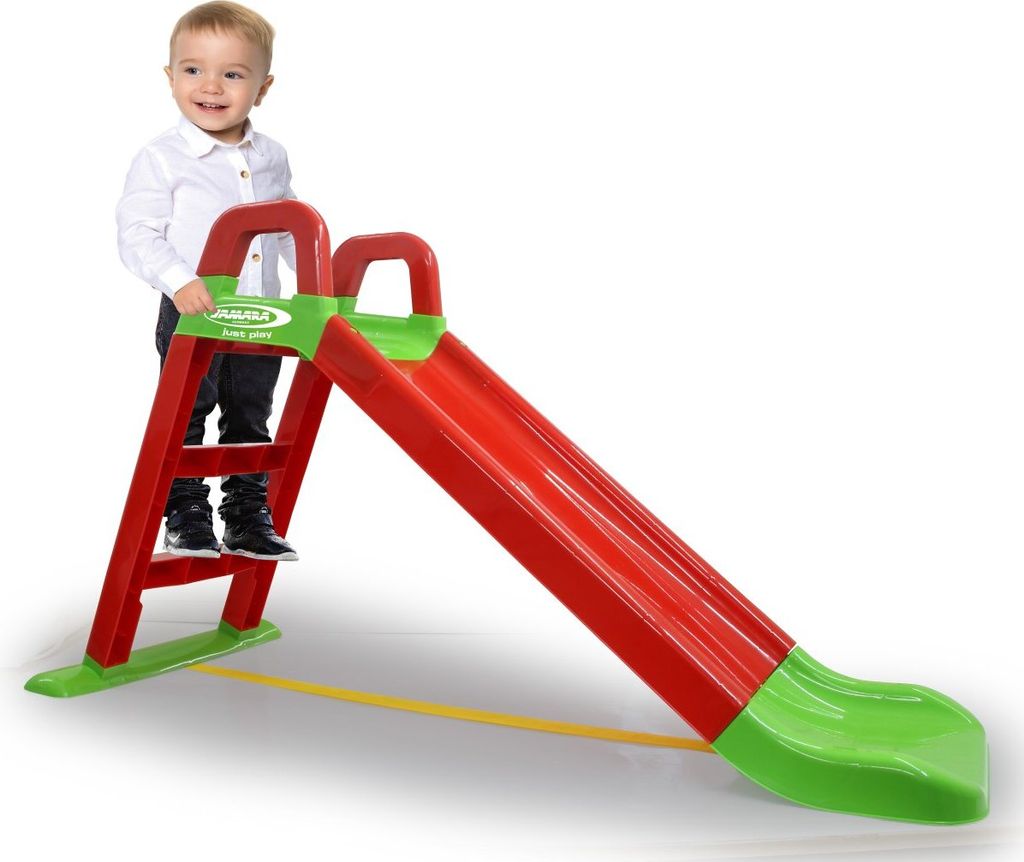 A child stands on the steps of a red and green slide.