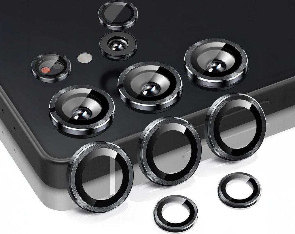 A collection of camera lens protectors for a smartphone, arranged on a dark surface and a white surface.