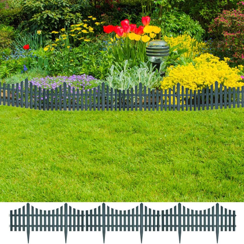 A garden with a lawn and a flower bed bordered by a fence.