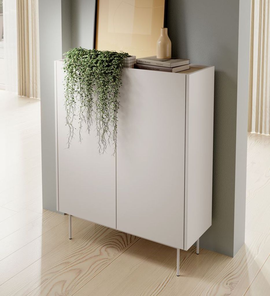 A modern white cabinet with a trailing plant on top, placed on a wooden floor.