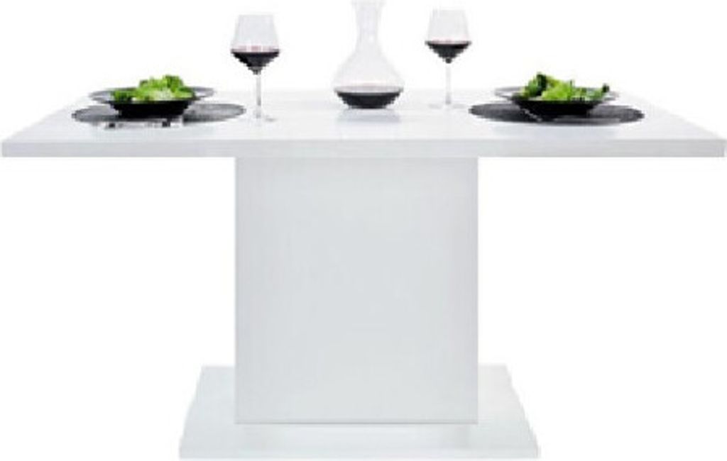 A white dining table set with two plates of salad, two wine glasses, and a decanter.