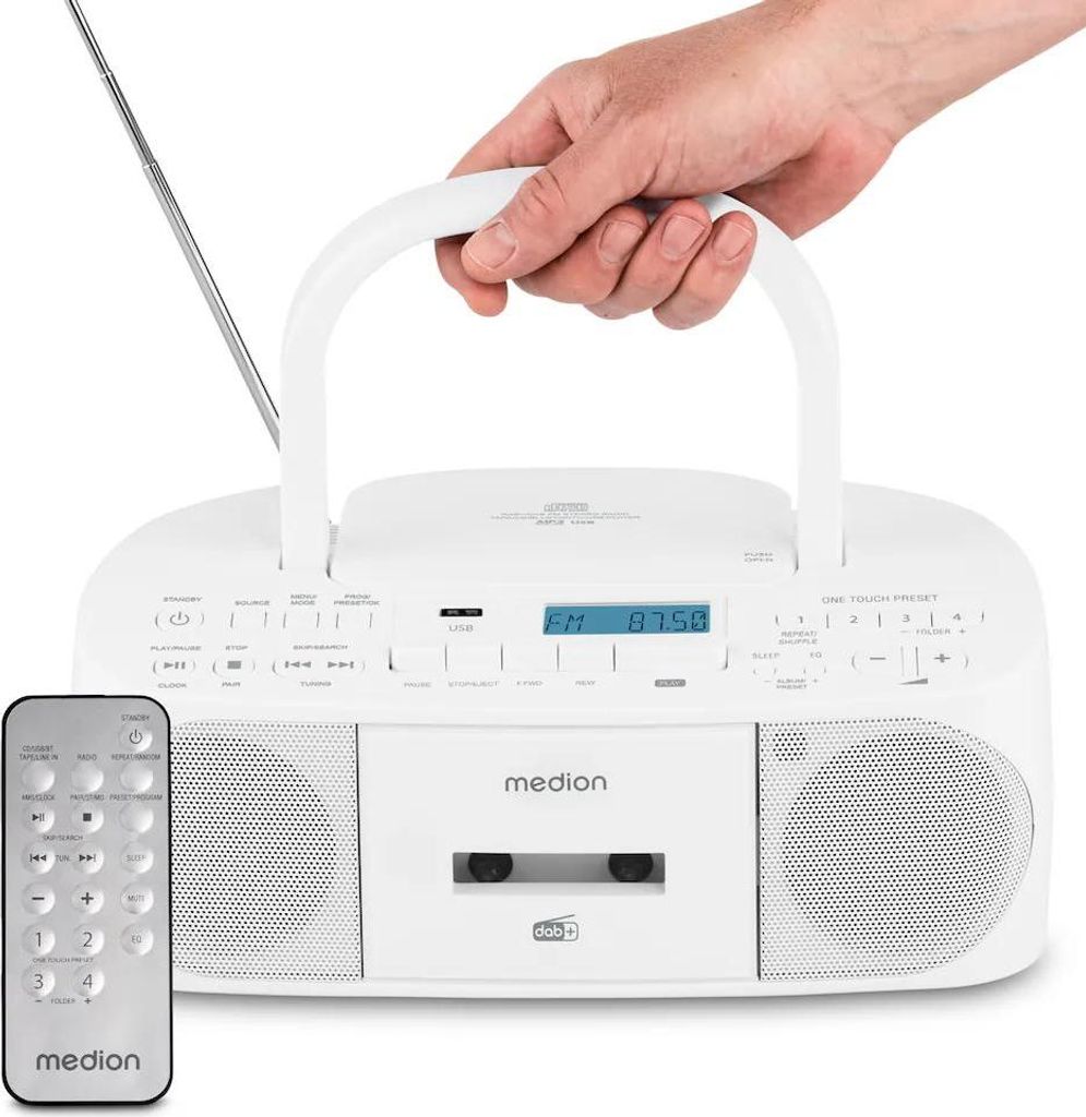A hand is holding the handle of a white Medion radiorecorder with a CD player and cassette deck. A remote control is in the foreground.