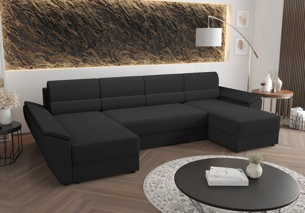 A dark gray U-shaped sectional sofa is shown in a modern living room setting, with a textured wall behind it and a coffee table in front.