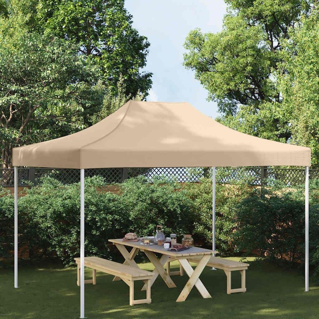 A party tent set up in a garden with a picnic table and benches underneath.