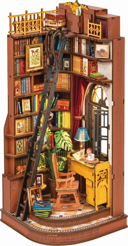 A miniature diorama of a cozy study nook with bookshelves, a desk, and a rocking chair.