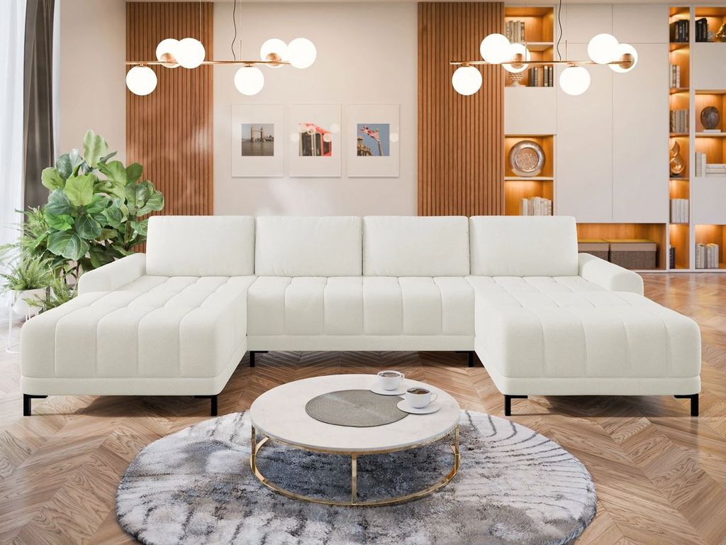 A modern living room with a large white sectional sofa, a round coffee table, and decorative wall art.