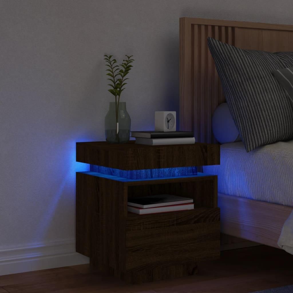 A bedside table with LED lights next to a bed.