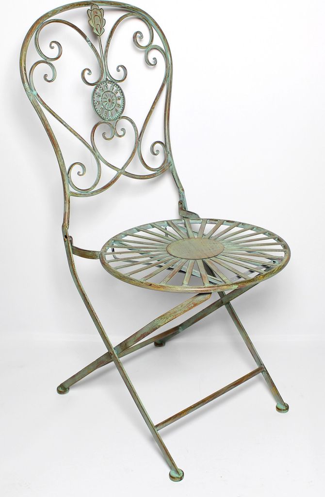 A vintage-style metal folding chair with a sunburst seat and ornate backrest, set against a white background.