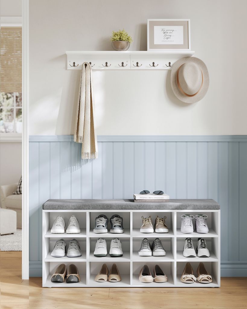 An entryway shoe storage bench with a shelf and coat hooks.
