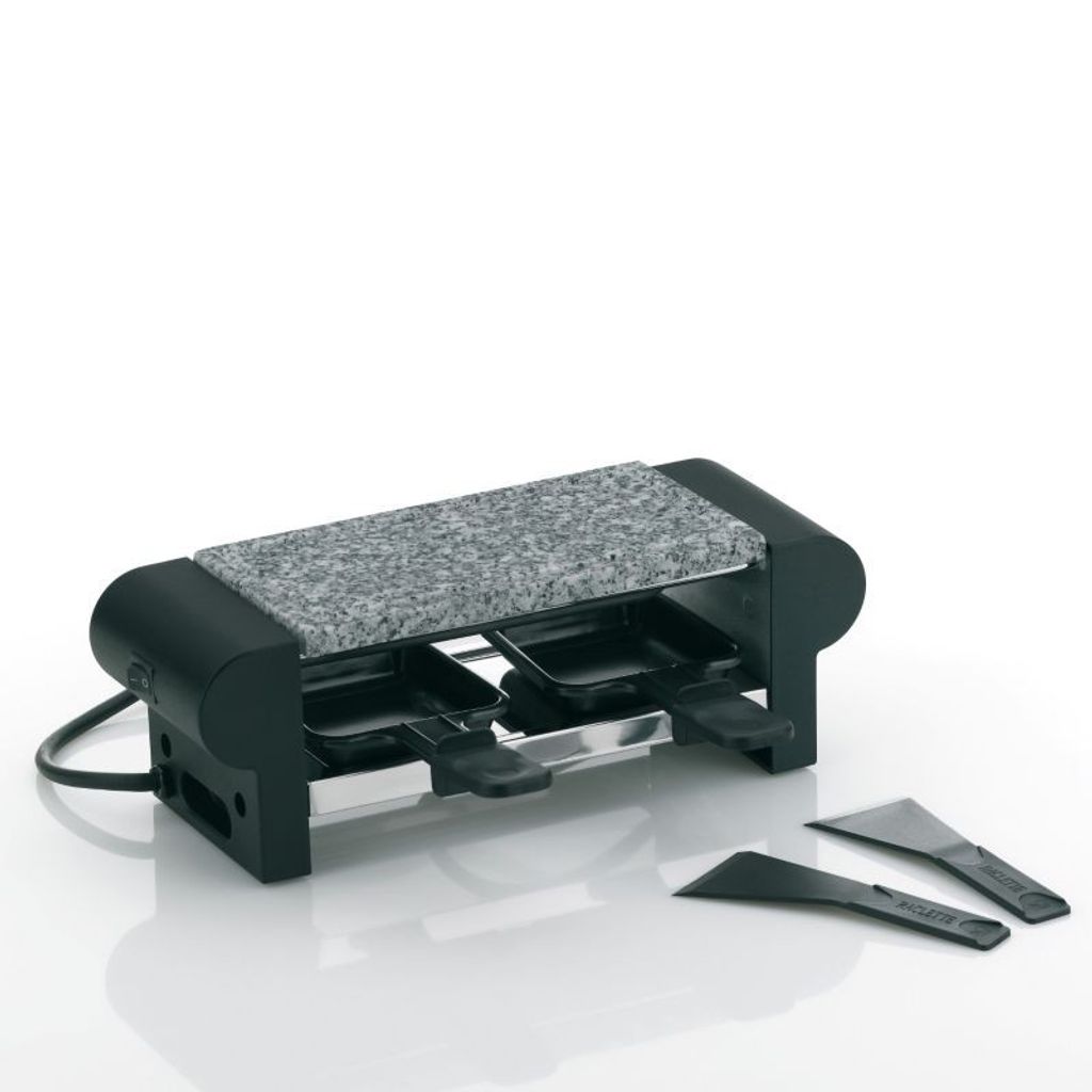 A raclette grill with a granite stone top and two small pans, along with two spatulas, is displayed against a white background.