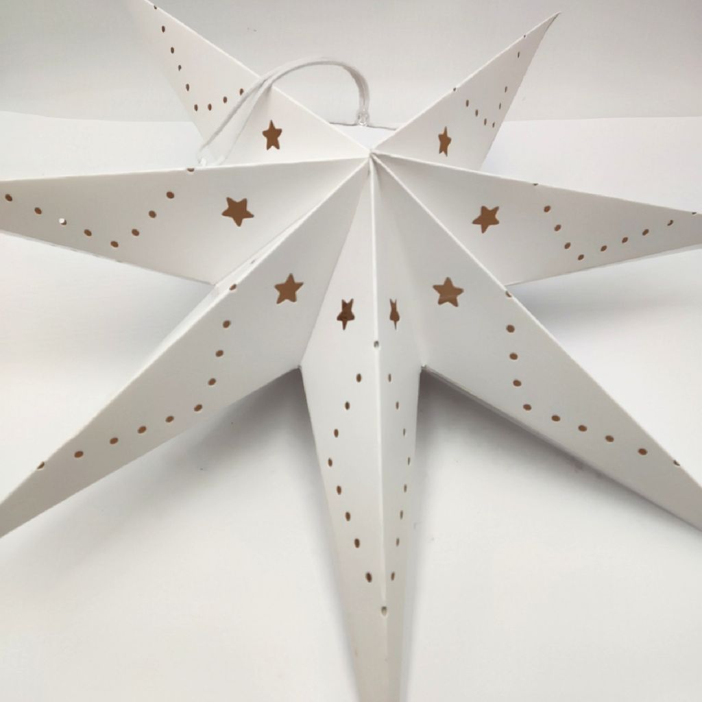 A white paper star lantern with gold star cutouts and dots, set against a white background.