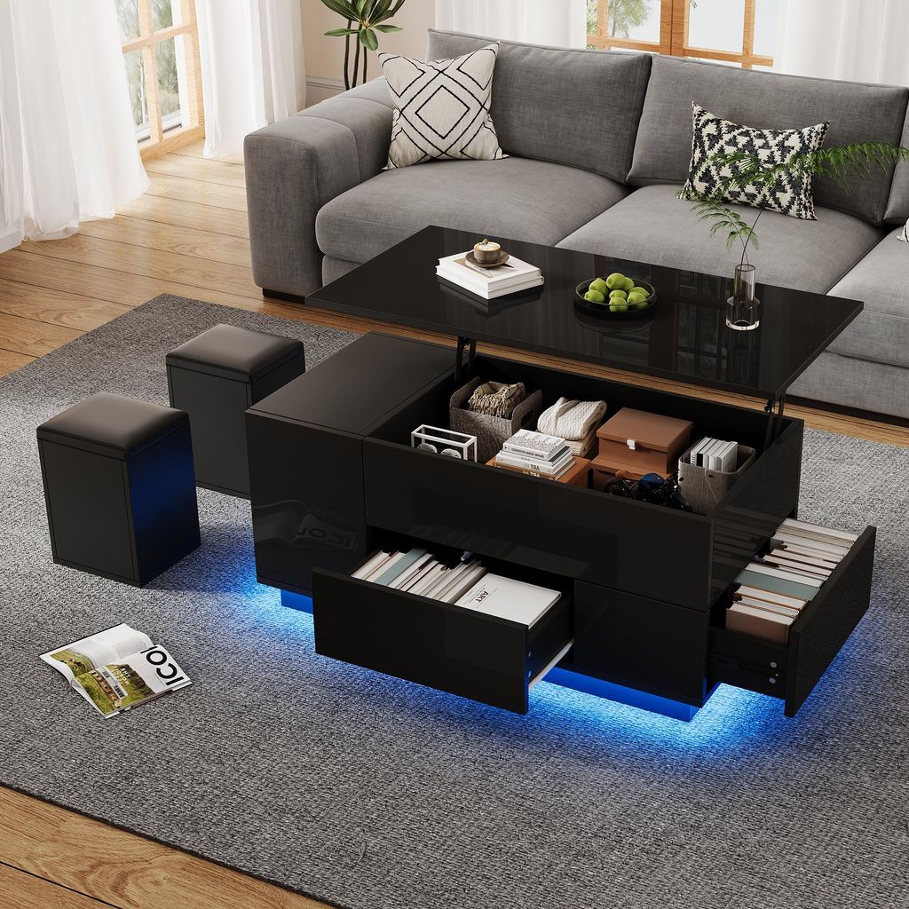 A modern living room scene featuring a black lift-top coffee table with storage and LED lighting, accompanied by two black ottomans, placed on a gray rug in front of a gray sectional sofa.