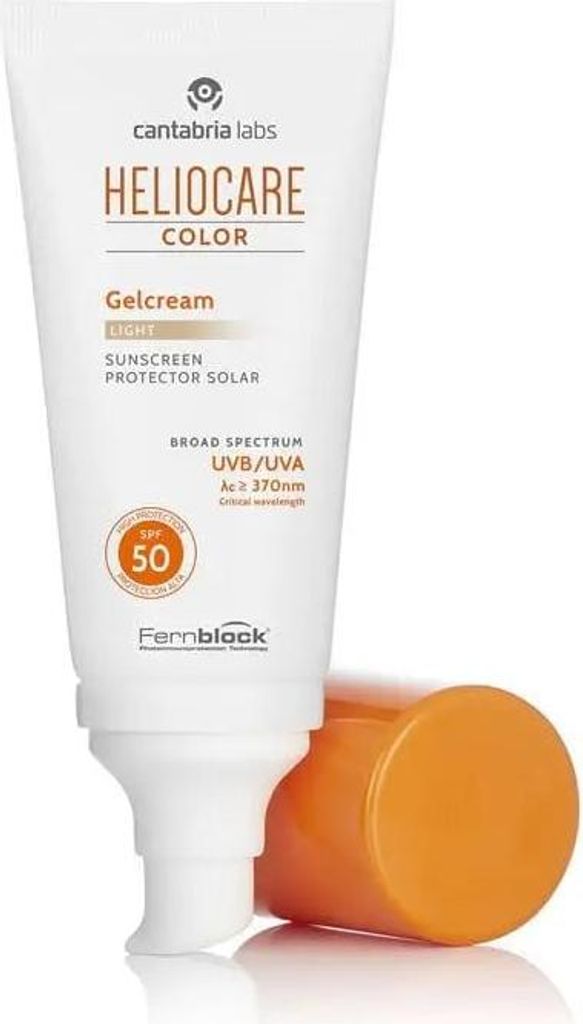 A tube of sunscreen with its cap off, resting on a reflective surface.