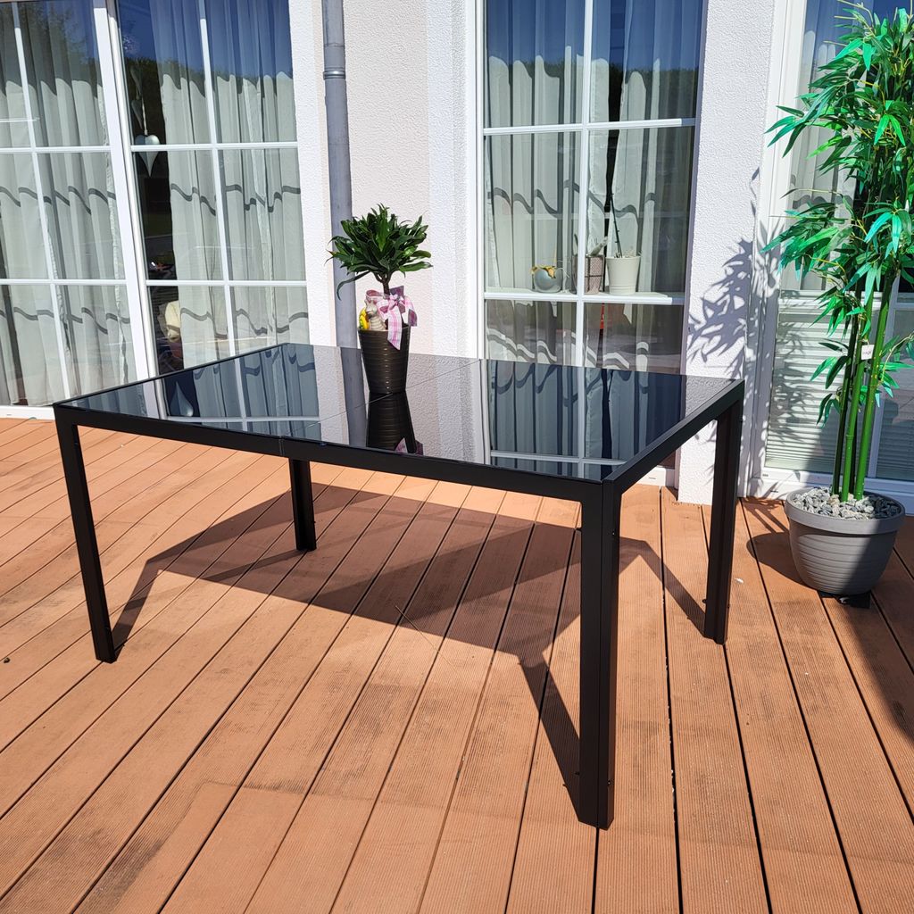 An outdoor table and chairs set on a wooden deck.