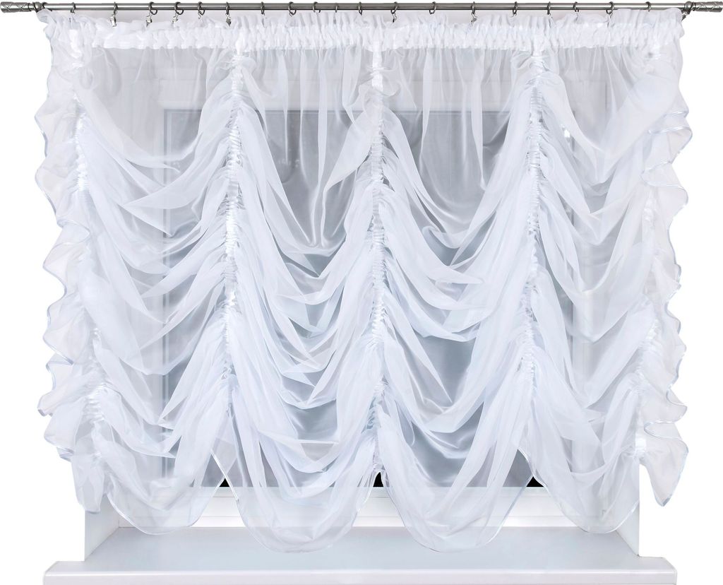 A white sheer curtain with gathered fabric hangs in front of a window.
