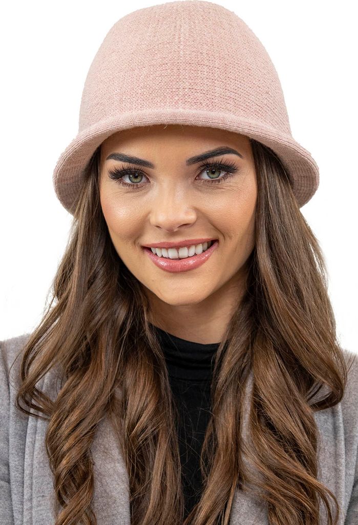 A woman wearing a pink hat and a gray cardigan.