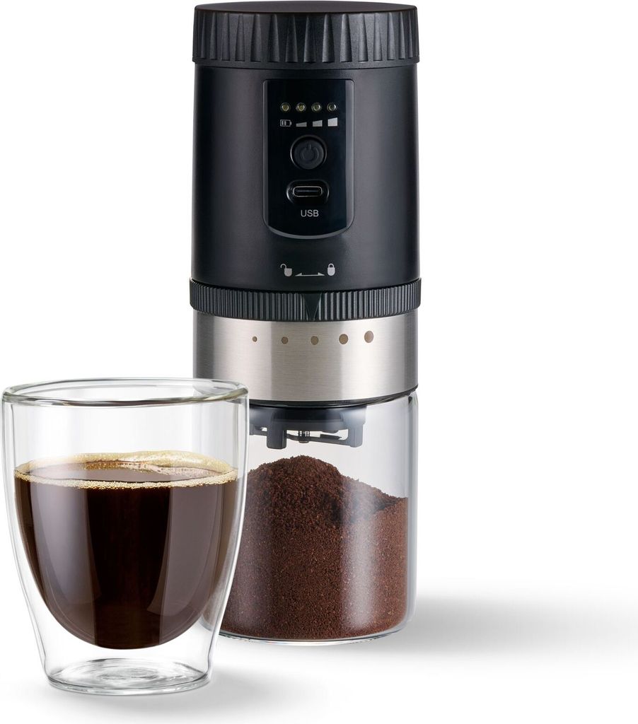A black and silver electric coffee grinder with a glass collection container is shown next to a glass of coffee.