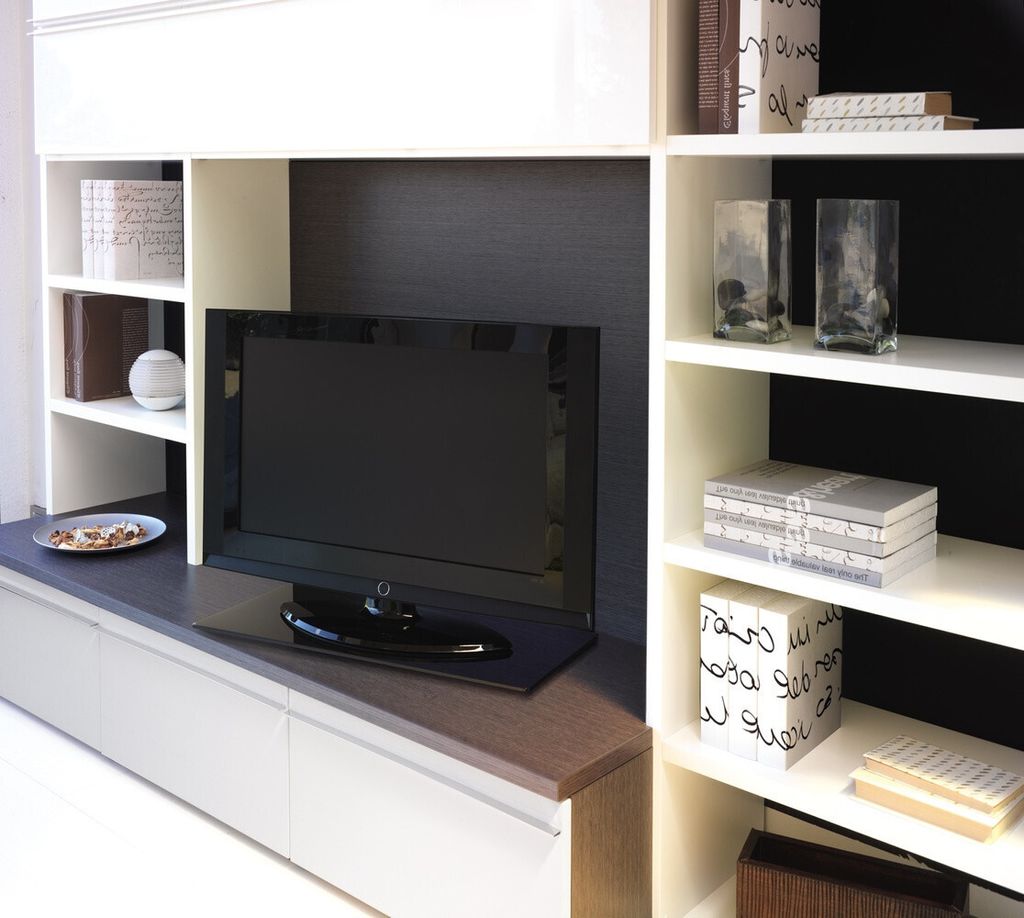A modern living room entertainment center with a TV and shelves.