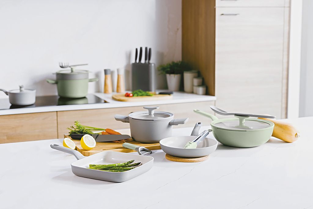 A collection of cookware and kitchen utensils arranged on a countertop.