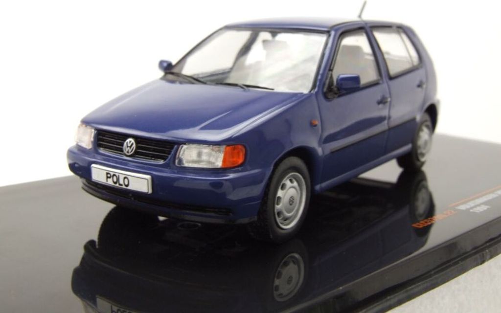 A blue Volkswagen Polo 3 model car is displayed on a black reflective surface against a white background.