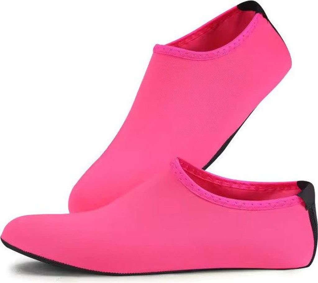 Paar leuchtend pinke Wasserschuhe mit schwarzen Sohlen, einer aufrecht stehend und einer flach liegend