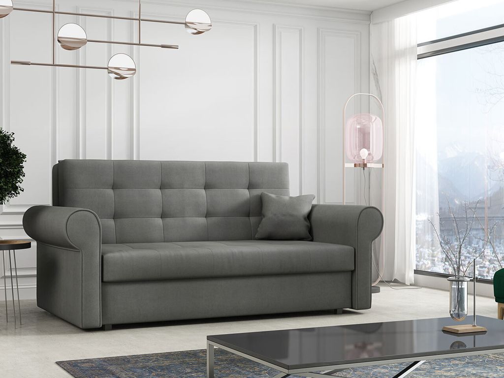 A gray sofa is shown in a well-lit living room with a large window overlooking a snowy landscape.
