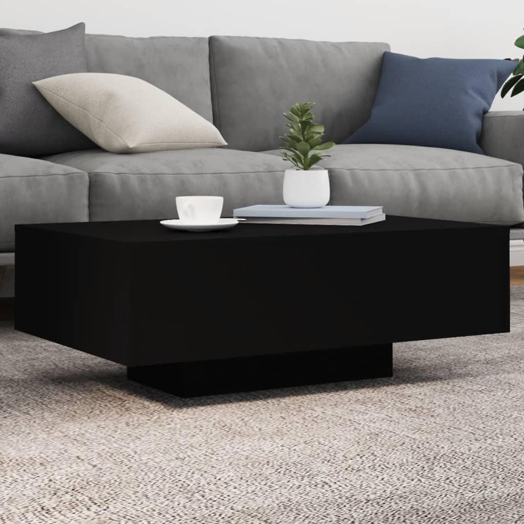 A black coffee table sits in front of a gray sofa on a gray carpet.