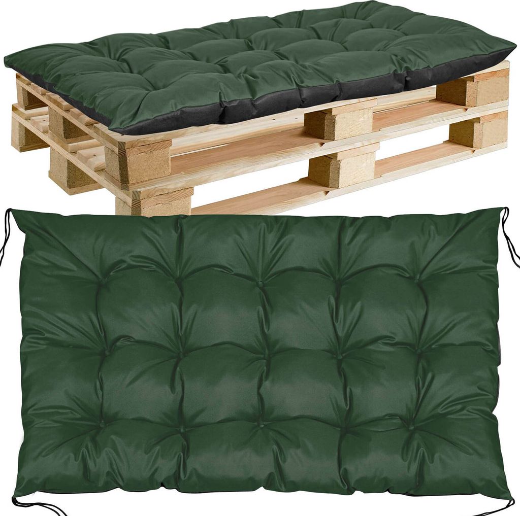 A green tufted cushion placed on a wooden pallet.