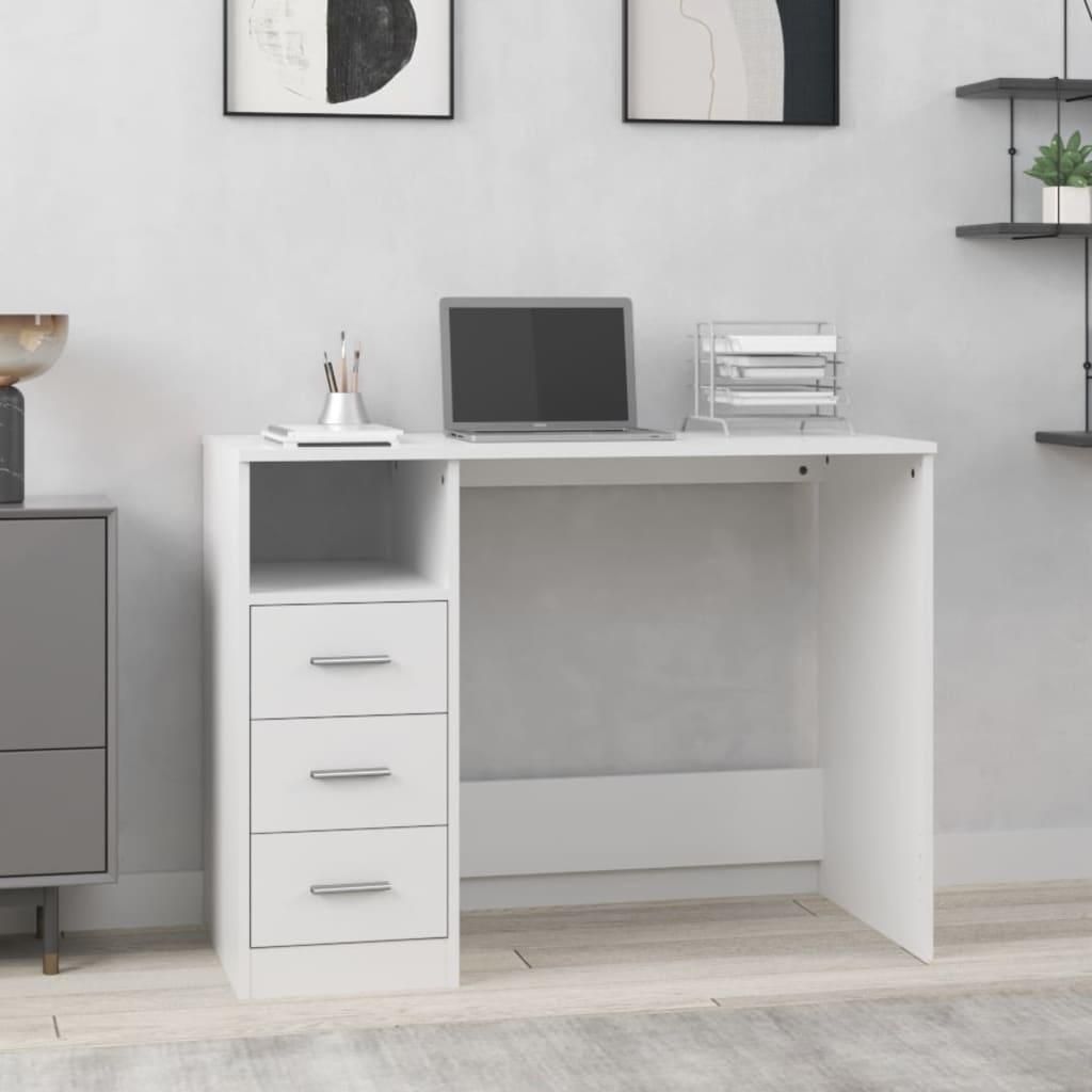 A white desk with drawers and a laptop on it, placed in a room with artwork on the wall.