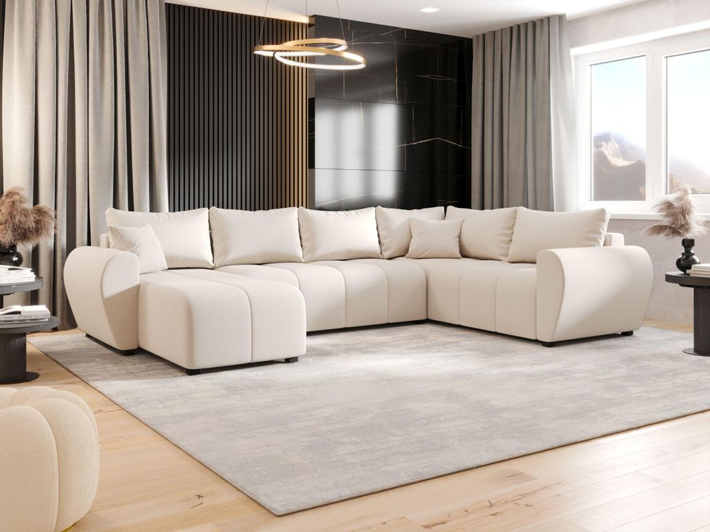 A modern living room with a large U-shaped sofa, curtains, and a decorative light fixture.