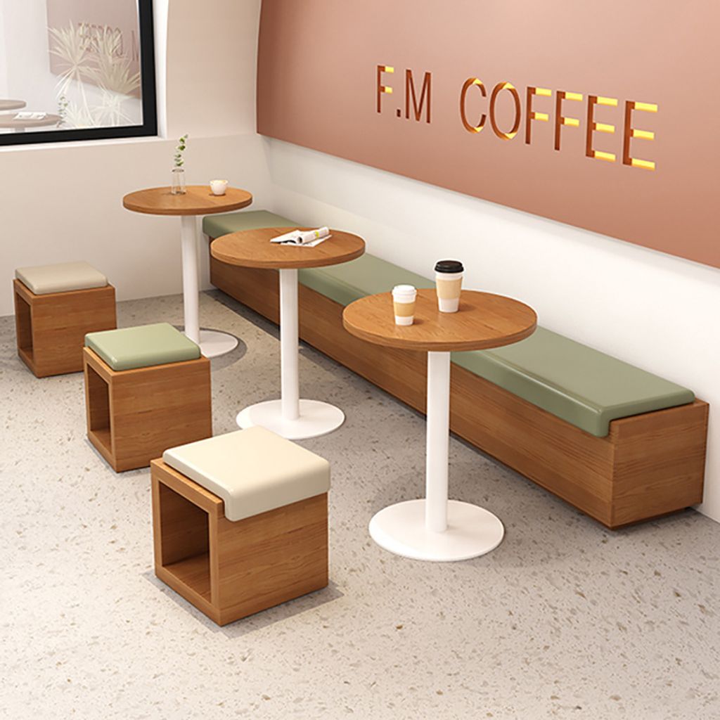 A coffee shop interior with tables, benches, and stools.