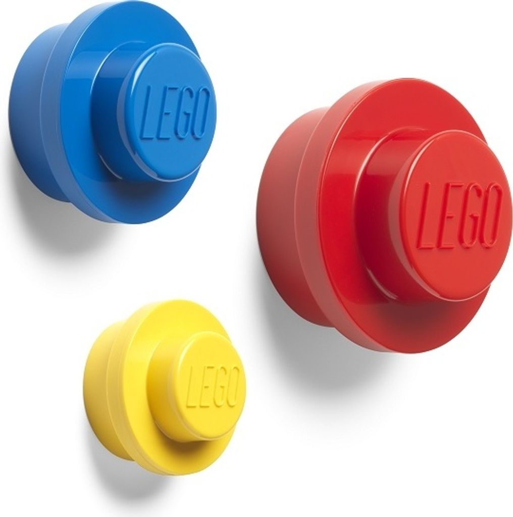 Three LEGO-style hooks in blue, red, and yellow are mounted on a white wall.