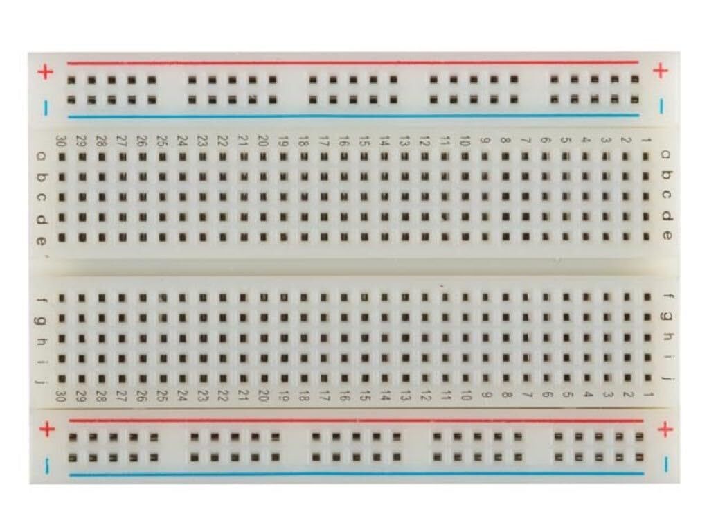 A top-down view of a white breadboard with blue and red power rails.
